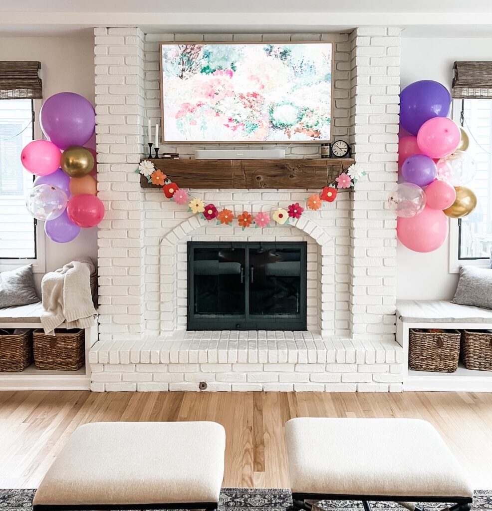 The fireplace with balloon garland and flower decorations.